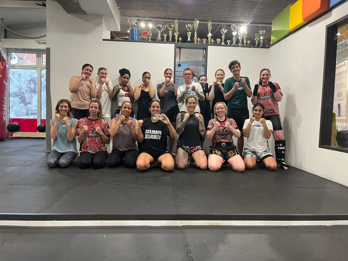 Die Frauen-Kickbox-Gruppe nach dem Training in Kampfpose